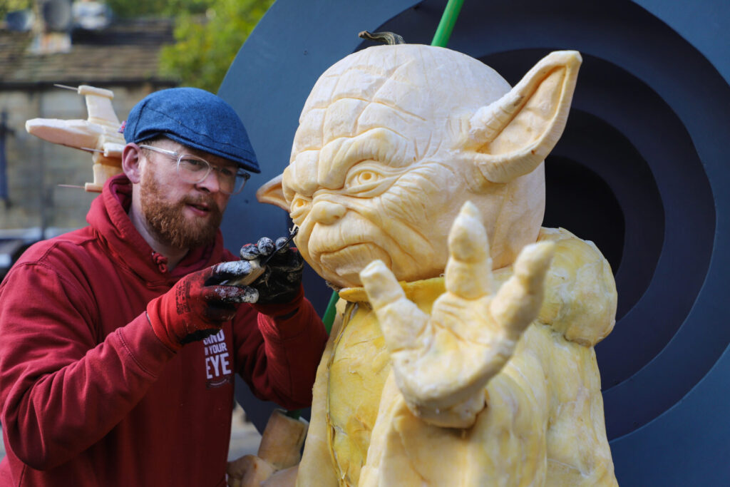 Photograph of a pumpkin being carved by Sand in Your Eye Director, Jamie.