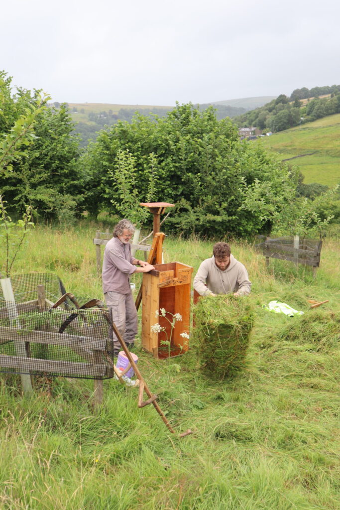 Volunteers baling hay using the 'peachy press'.