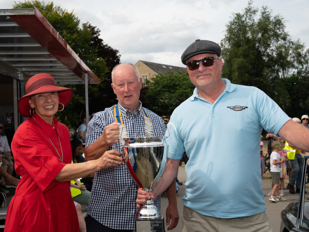 A silver trophy is handed to a Hebden Bridge Vintage Weekend attendee.