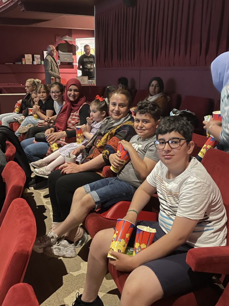Families seated in Hebden Bridge Picture House auditorium waiting to watch a film, as part of the Making Friends Project run by Friends of the Picture House