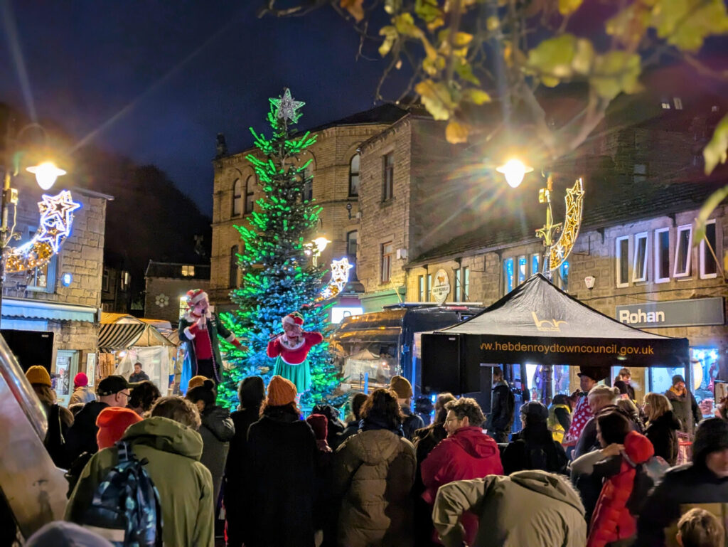 Crowds gather around the christmas tree in the Square at Hebden bridge just after the lights switch on, 2025.